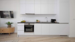 A modern kitchen with white cabinetry, a built-in oven, and a coffee maker. - Stylish Studios with Balconies | Close to the Underground | City Centre (Warszawa)