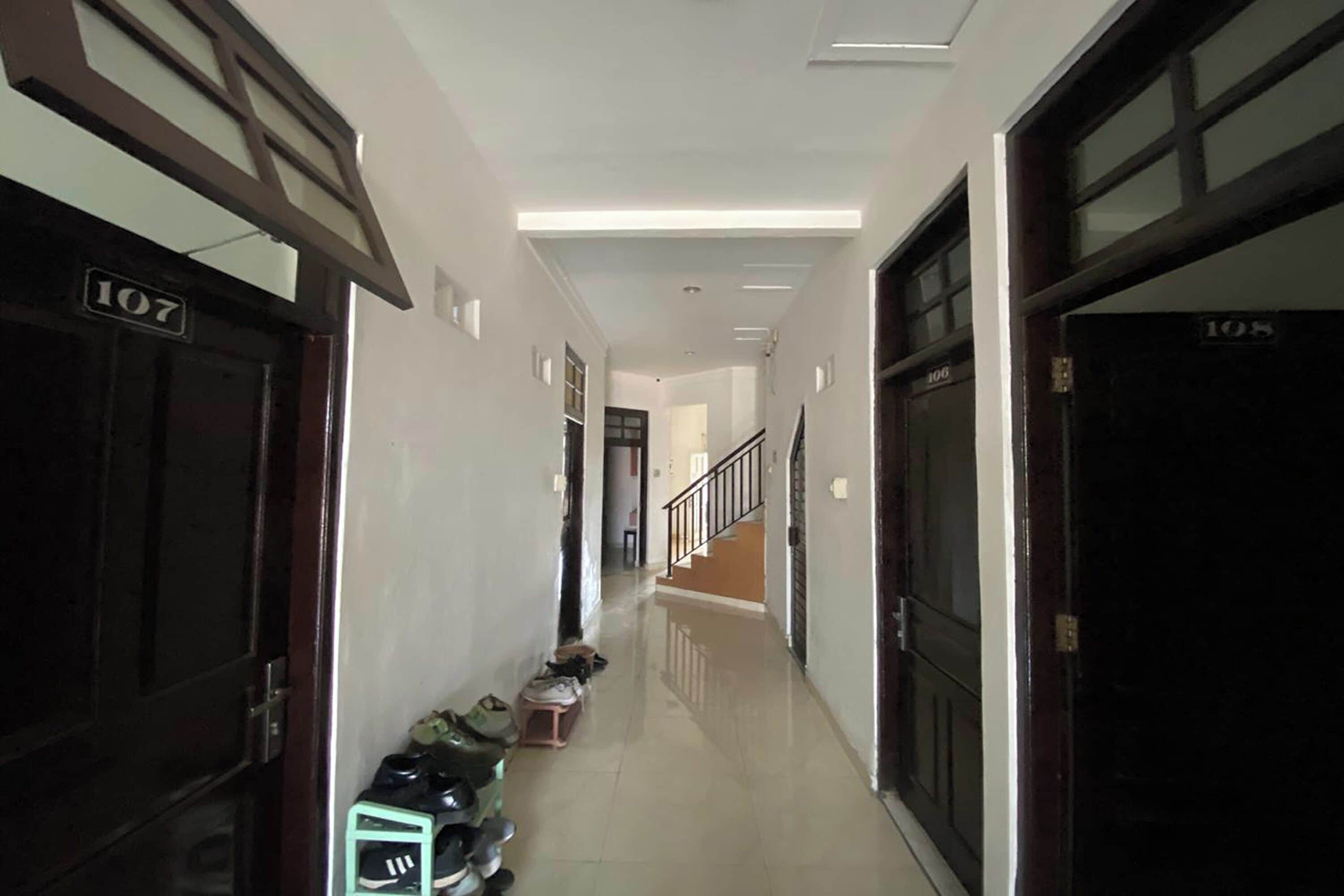 Un pasillo con puertas numeradas 107 y 108 que dan a varias habitaciones.