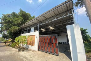 Un edificio con techo metálico y entrada protegida por una reja.