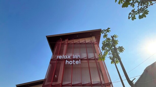 Um edifício com uma placa que diz 'relax inn hotel'.