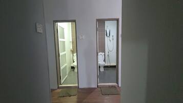 Un couloir avec deux portes donnant accès à une salle de bain et à des toilettes.