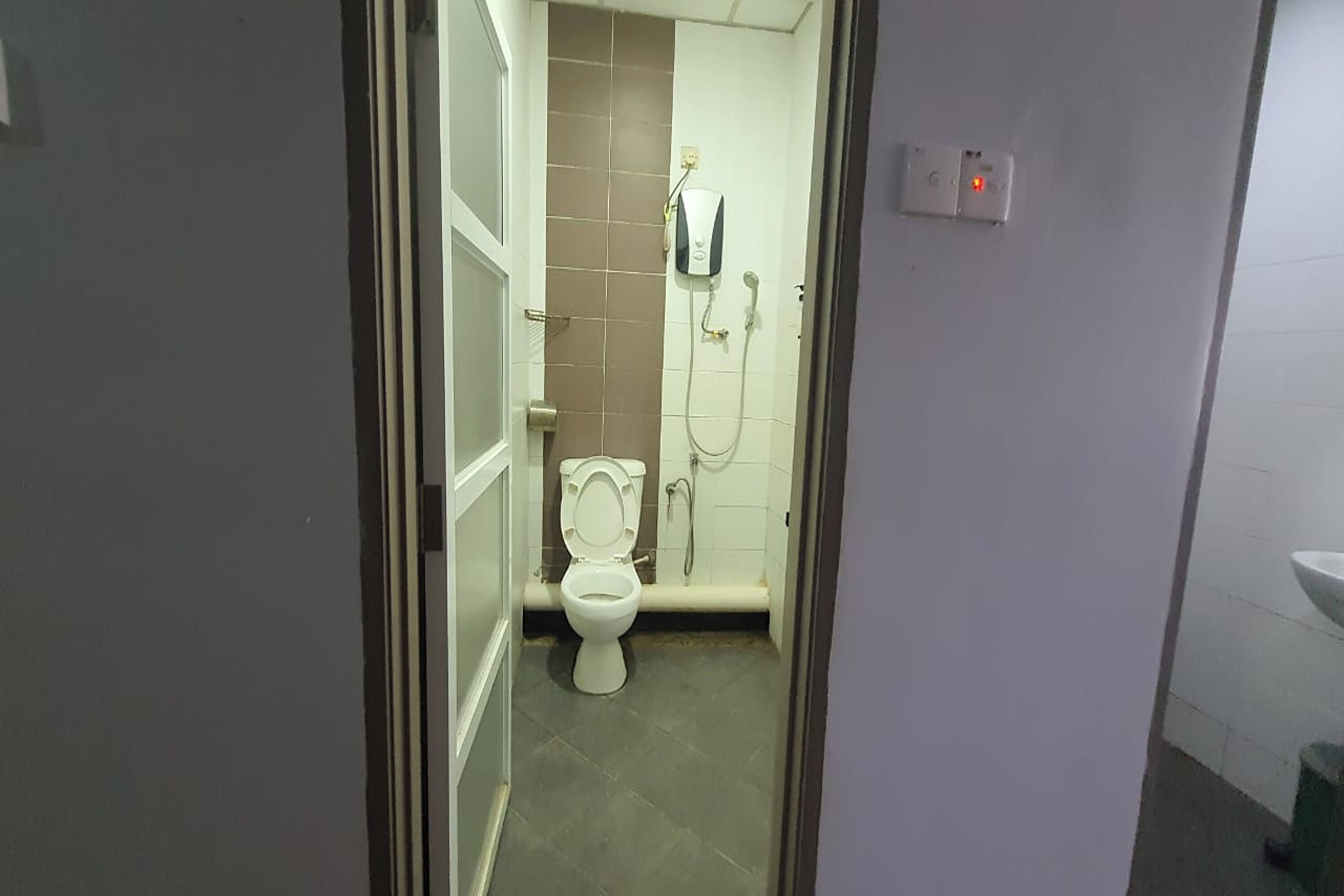 A bathroom with a toilet, a shower, and a sink.