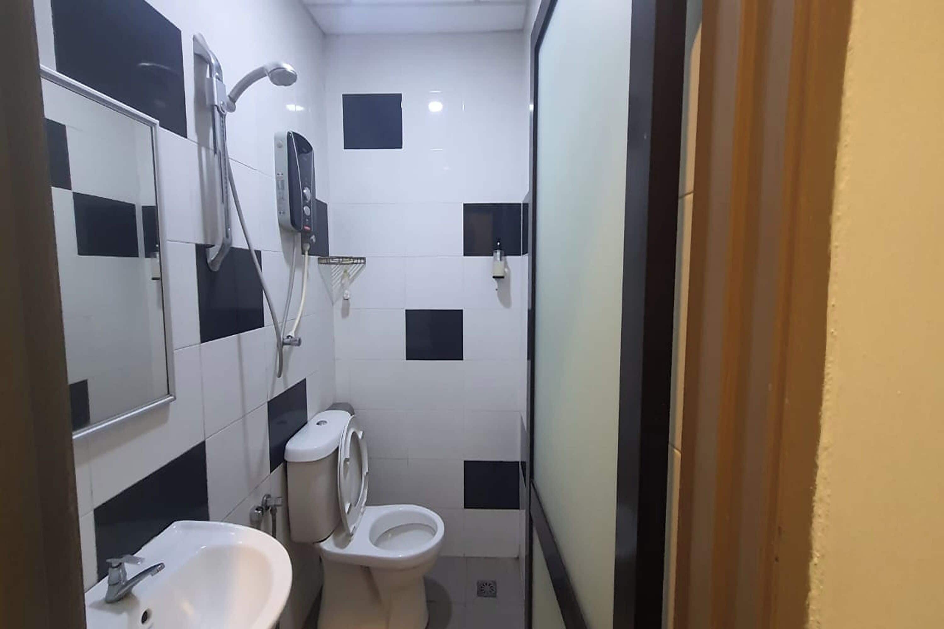 Une petite salle de bain avec un lavabo blanc, des toilettes et un espace douche.