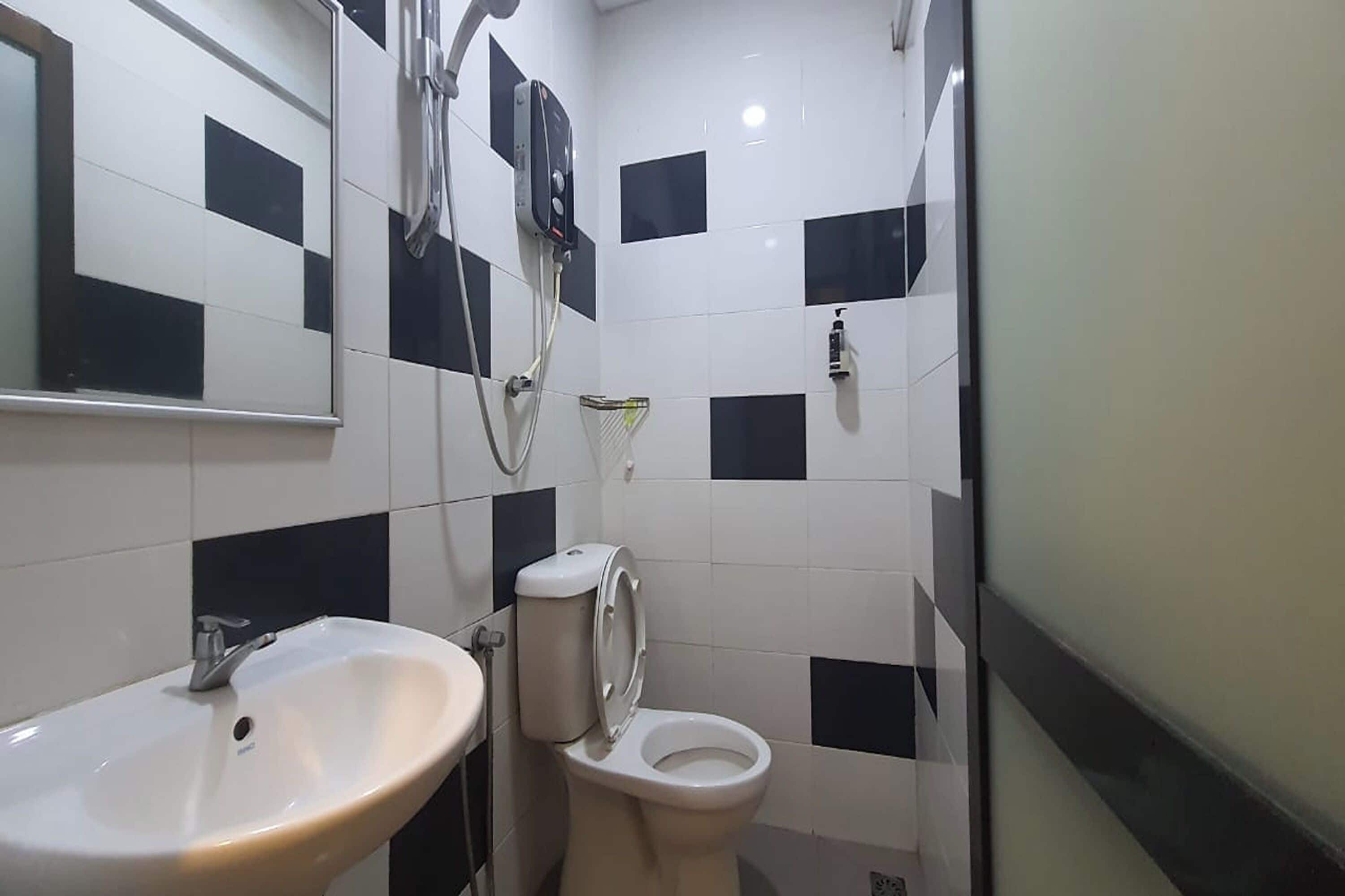 A bathroom with a sink, toilet, and a mirror.