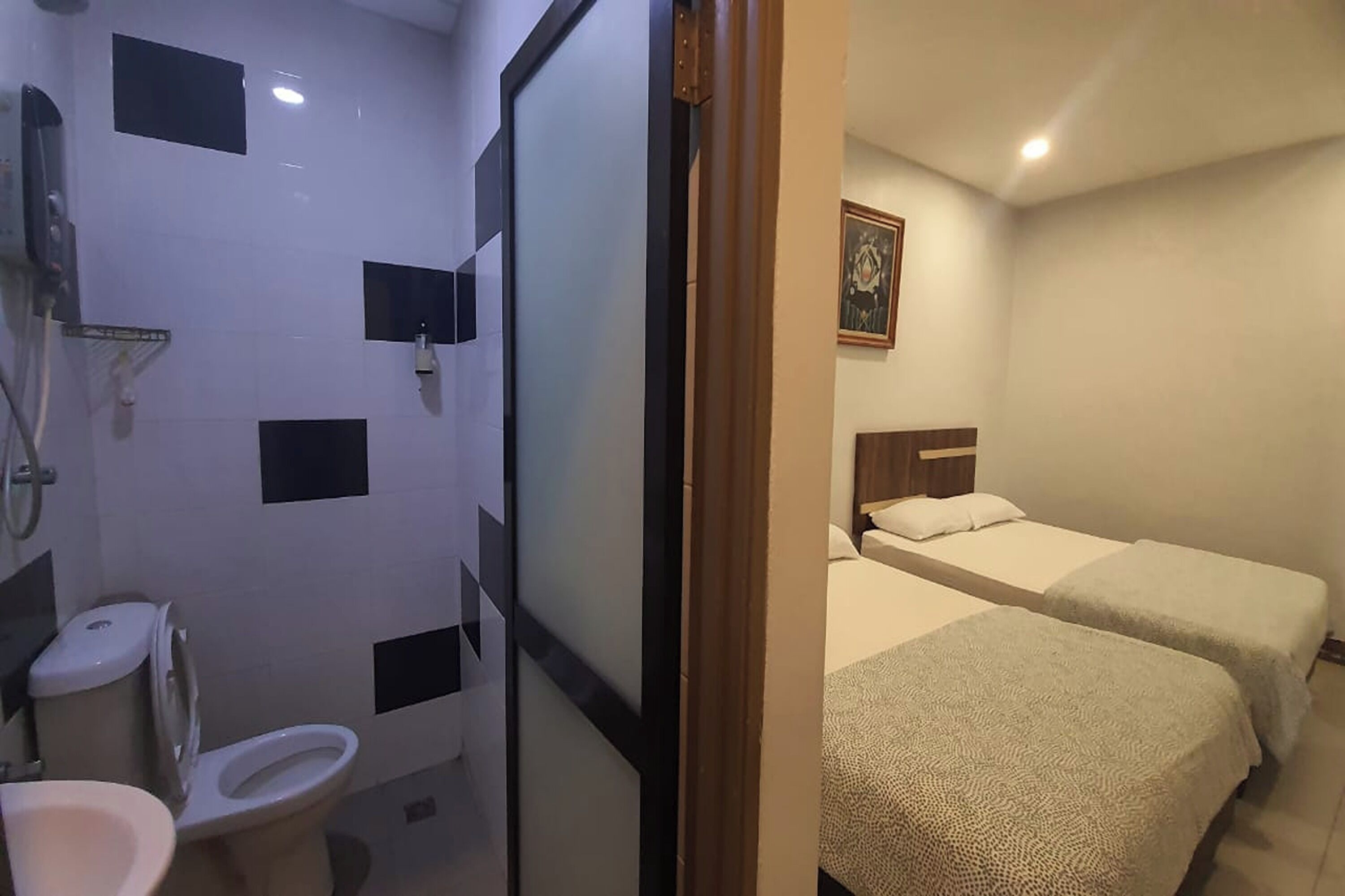 Ein Hotelzimmer mit Bad und zwei Betten.