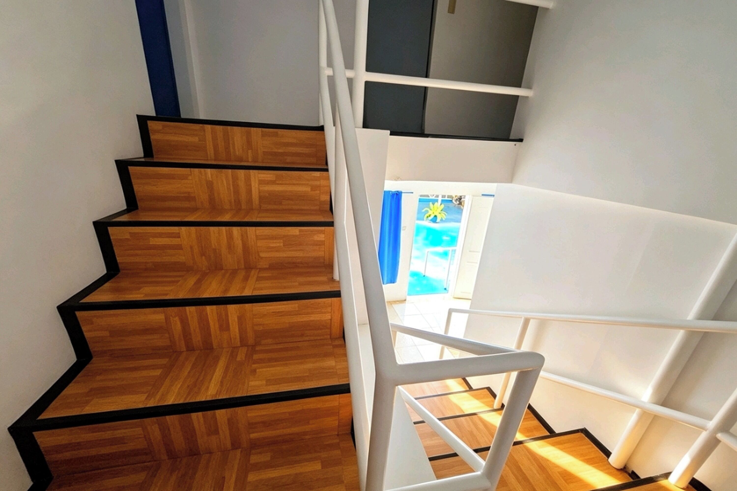 Una scala con gradini in legno e ringhiere bianche.