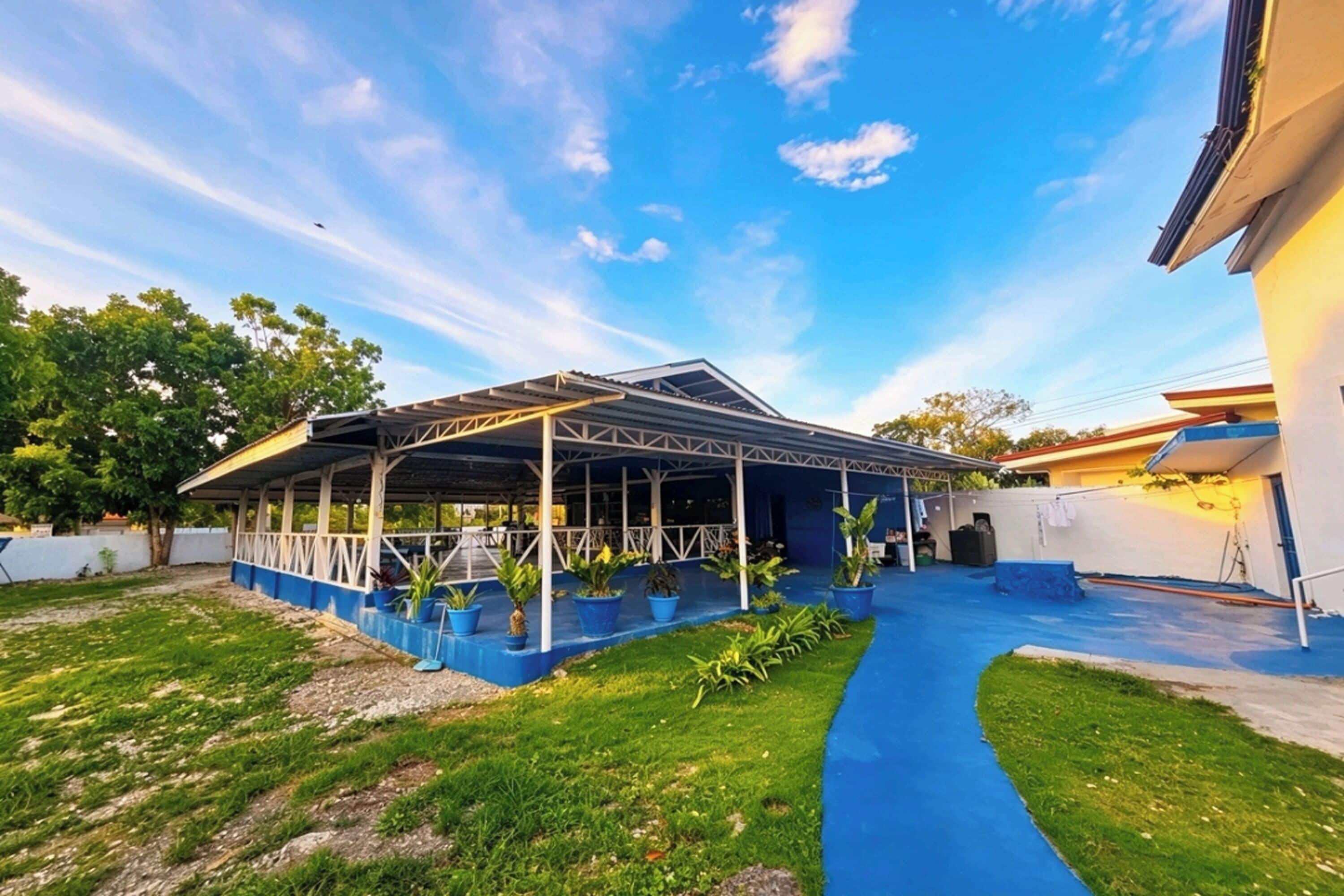 A covered outdoor area with a blue pathway leading to a building.