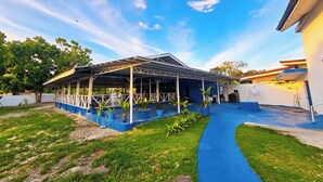 A covered outdoor area with a blue pathway leading to a building.