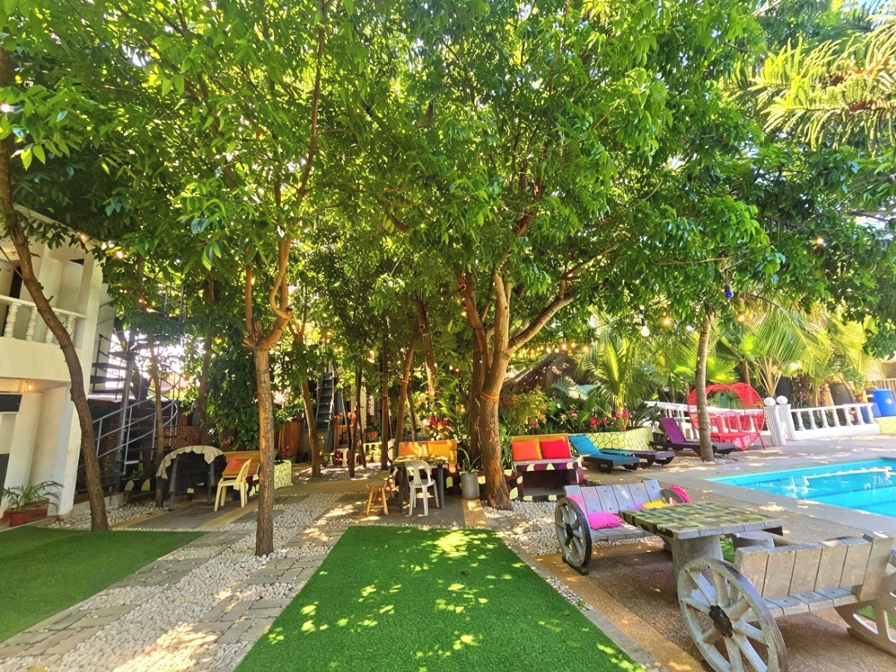 A poolside area with a wooden deck, seating, and a pool.