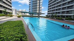 A swimming pool surrounded by modern buildings, with a clear sky above. - SMDC Light Residences Condominium near Boni MRT (Mandaluyong)