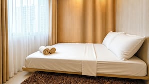 A modern bedroom with a bed, curtains, and a view of buildings outside. - SMDC Light Residences Condominium near Boni MRT (Mandaluyong)