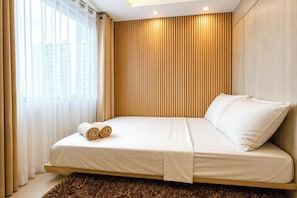 Ein modernes Schlafzimmer mit Bett, Vorhängen und Blick auf Gebäude.
