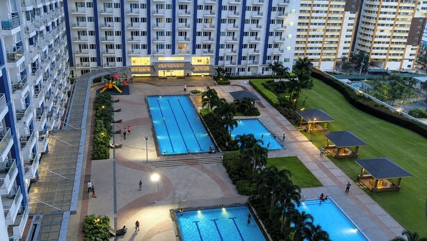 A residential building with multiple balconies, a children's play area, and several swimming pools. - SMDC Light Residences Condominium near Boni MRT (Mandaluyong)