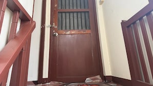 A brown door with a window and a metal handle. - Sleep Break Hostel Sathon (Bangkok)