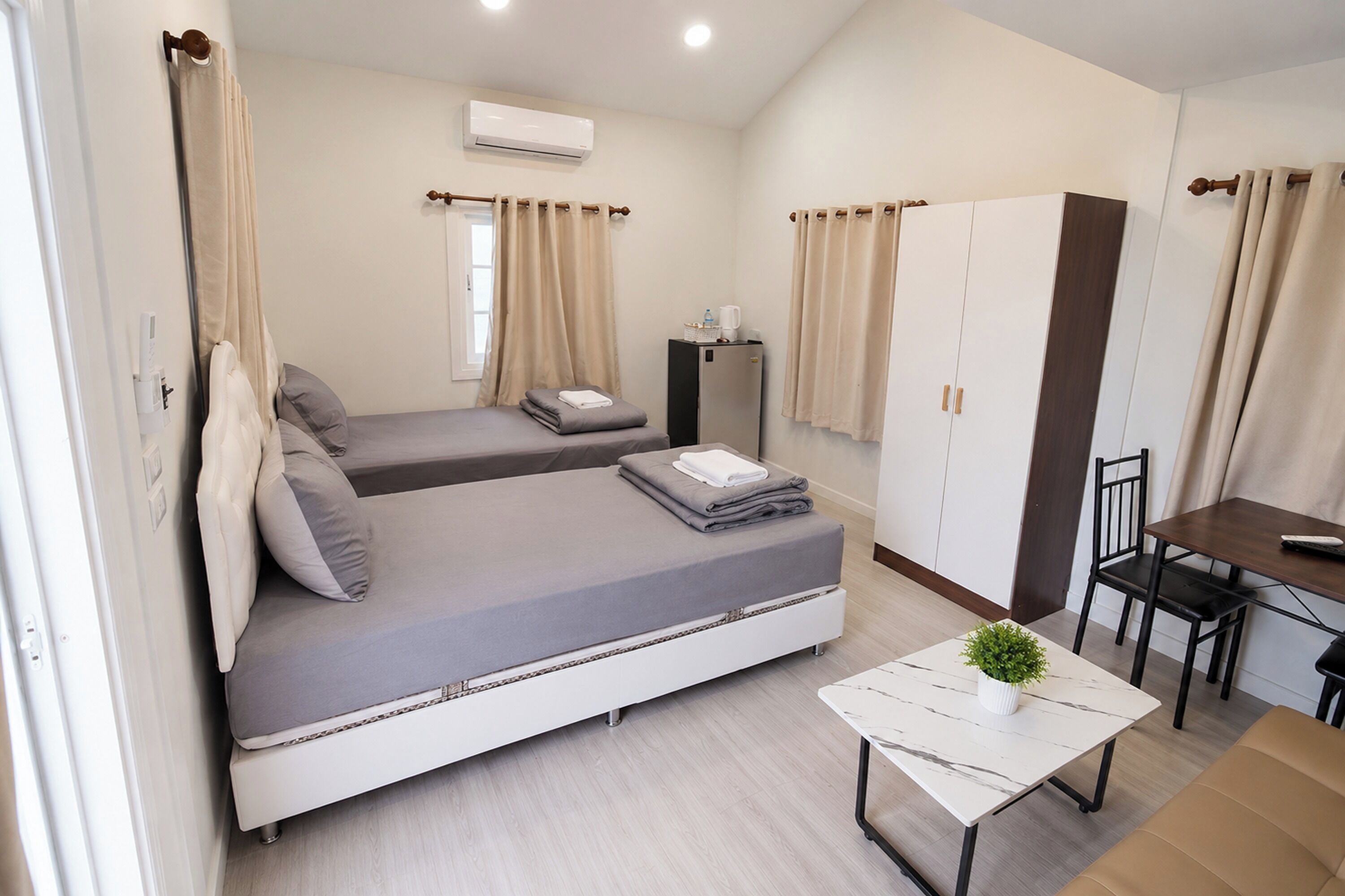 Une chambre d’hôtel de taille réduite, comprenant un lit, une petite table, une chaise et une armoire.