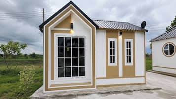 A small, single-story building with a gabled roof, a large front window, and a smaller window on the side.