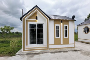 A small, single-story building with a gabled roof, a large front window, and a smaller window on the side.