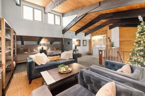 A cozy living room with a fireplace, a coffee table, and a Christmas tree. - Wood Fireplace | Hot Tub | Bust Stop at Condo | Arcade Games (Steamboat Springs)
