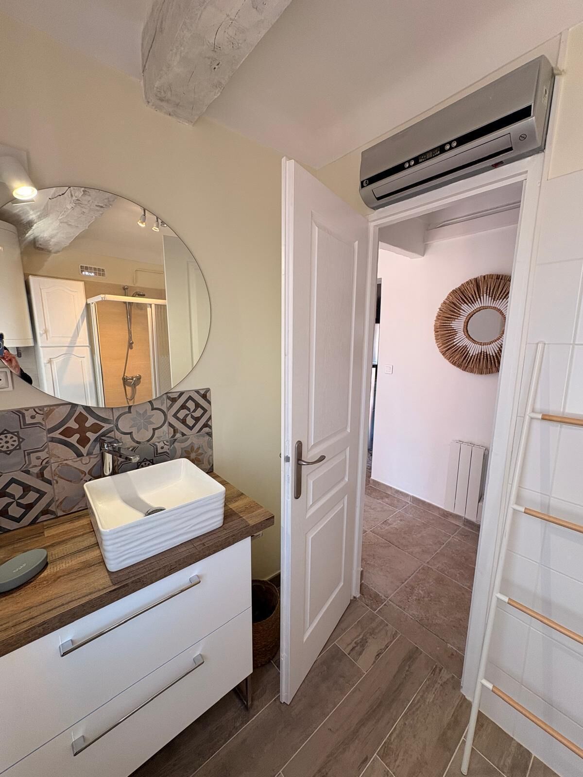 A bathroom with a white sink, a mirror, and a shower.