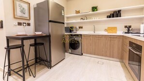 A modern kitchen with a built-in washing machine, a refrigerator, and a microwave.