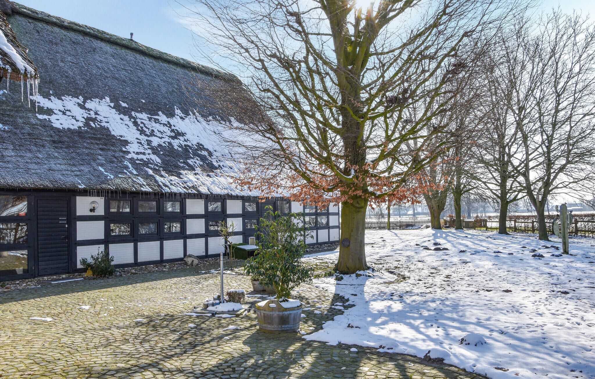 Een traditioneel gebouw met rieten dak en een kinderafdeppelsteentjes binnenplaats.