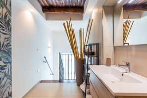 A modern bathroom with a large mirror, white sink, and a wooden ceiling. - Residenza Partanna by Napoliapartments (Naples)