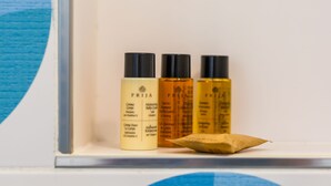 Tre flasker af PRIJA hudplejeprodukter står på en hylde.