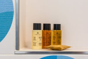 Drei Flaschen PRIJA Körperpflegeprodukte auf einem Regal.