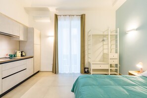 A modern bedroom with a bed, a wardrobe, a bedside table, and a bathroom with a shower. - Mergellina in Napoli (Naples)