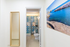 Ein Badezimmer mit Dusche, Toilette und einer Wandverkleidung.