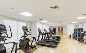 A fitness center with treadmills, stationary bikes, and weight machines.