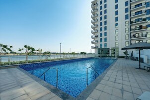 Una piscina al aire libre, sillones reclinables de piscina