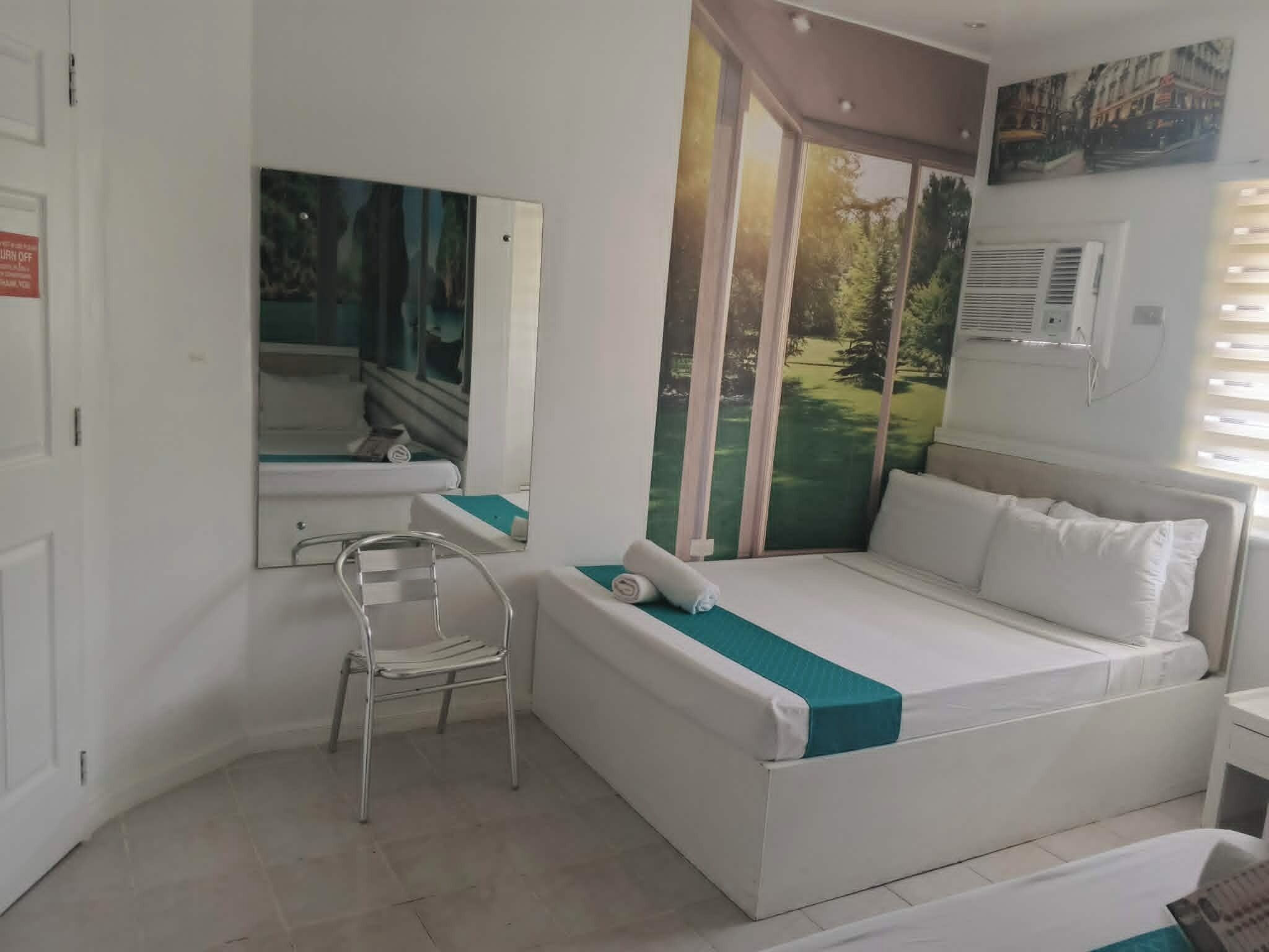 Een slaapkamer met een bed, een stoel, een raam en een deur.