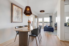 A modern dining area with a round table, chairs, and a pendant light. - Aurora Sky Penthouse By Lapland Host (Rovaniemi)