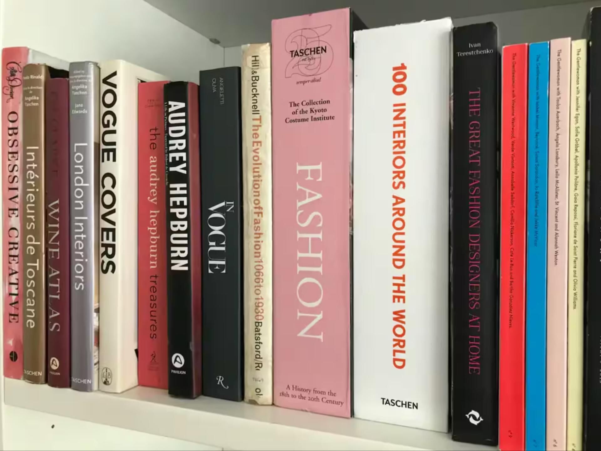 Une bibliothèque contenant une variété de livres, notamment des ouvrages sur la mode et le design.