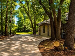 A pathway leading to a building surrounded by trees. - Lake Bluff Retreat (Marianna)