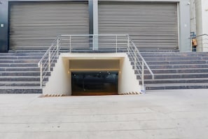 A set of concrete steps leading up to a building entrance with a metal staircase.