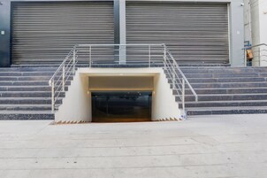 Una serie de escalones de hormigón que llevan a la entrada de un edificio, con una escalera de metal.