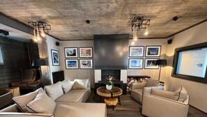 Una sala de estar moderna con un sofá modular, una mesa de centro redonda y una chimenea.