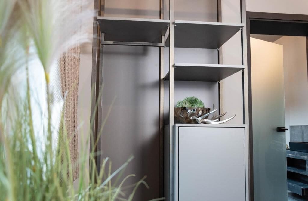 Ein modernes Interieur mit einer eingebauten Regaleinheit, einer kleinen Pflanze und dekorativen Accessoires.