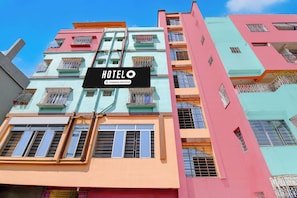 A multi-story hotel building with balconies and a sign indicating it is a company-serviced hotel. - Chittaranjan Railway (Jamtara)