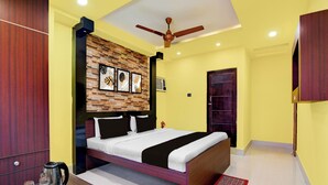 Un dormitorio con cama, cabecera de madera, ventilador de techo, aire acondicionado de pared y una puerta.