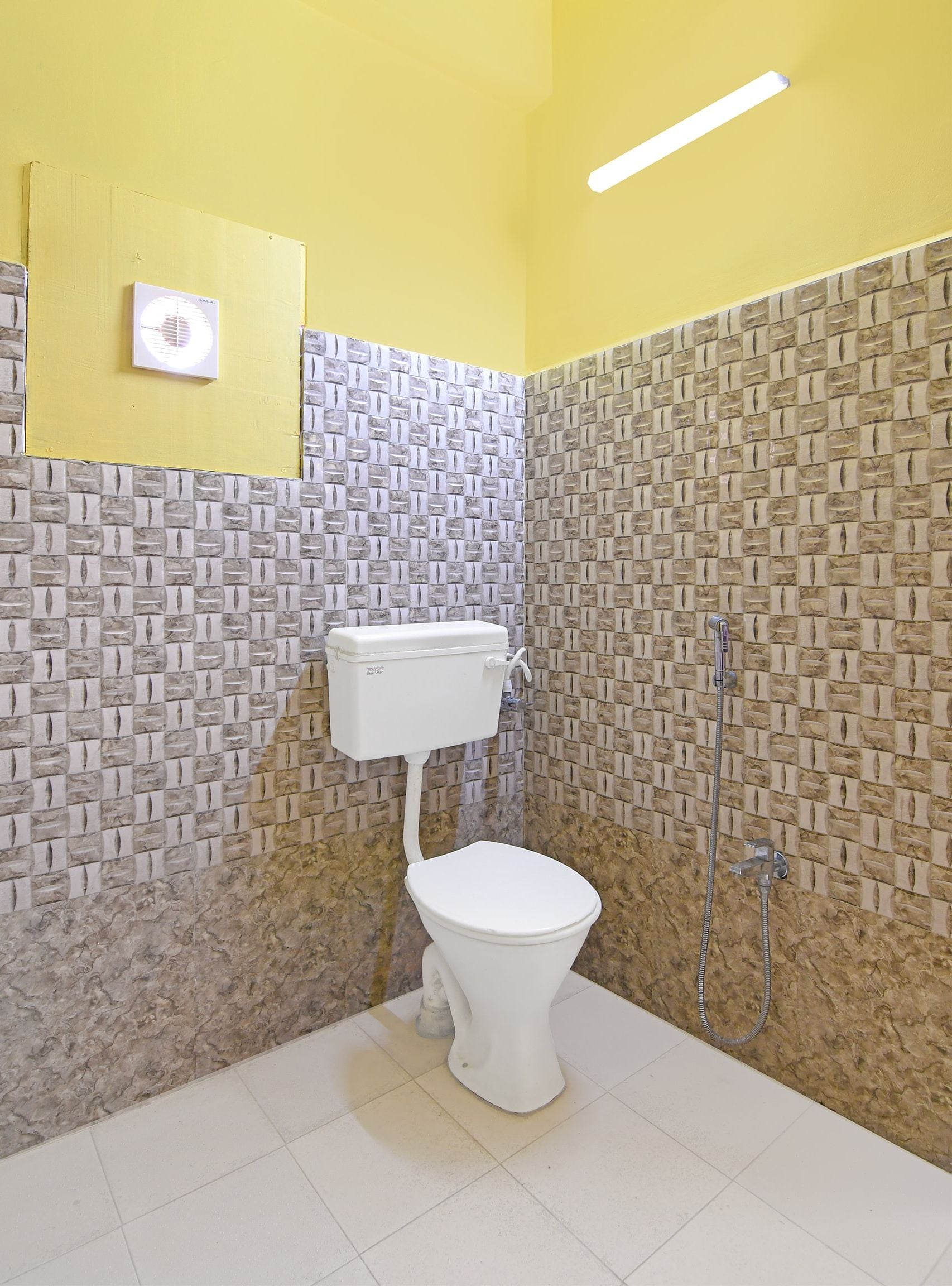 Un baño con inodoro, ducha y calentador de pared.