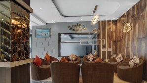 Un interior moderno con muebles de mimbre, un espejo grande y un reloj en la pared.