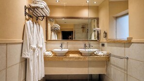 Une salle de bain moderne avec deux lavabos, un grand miroir et une douche à l’italienne.