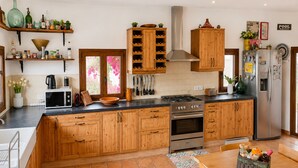 A kitchen with wooden cabinets, a stove, oven, and a refrigerator. - Canyop, 5StarsHome Villa, Mallorca (Campos)