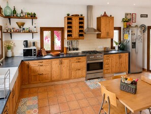 Eine Küche mit Holzausstattung, einem Herd, einem Backofen und einem Kühlschrank.
