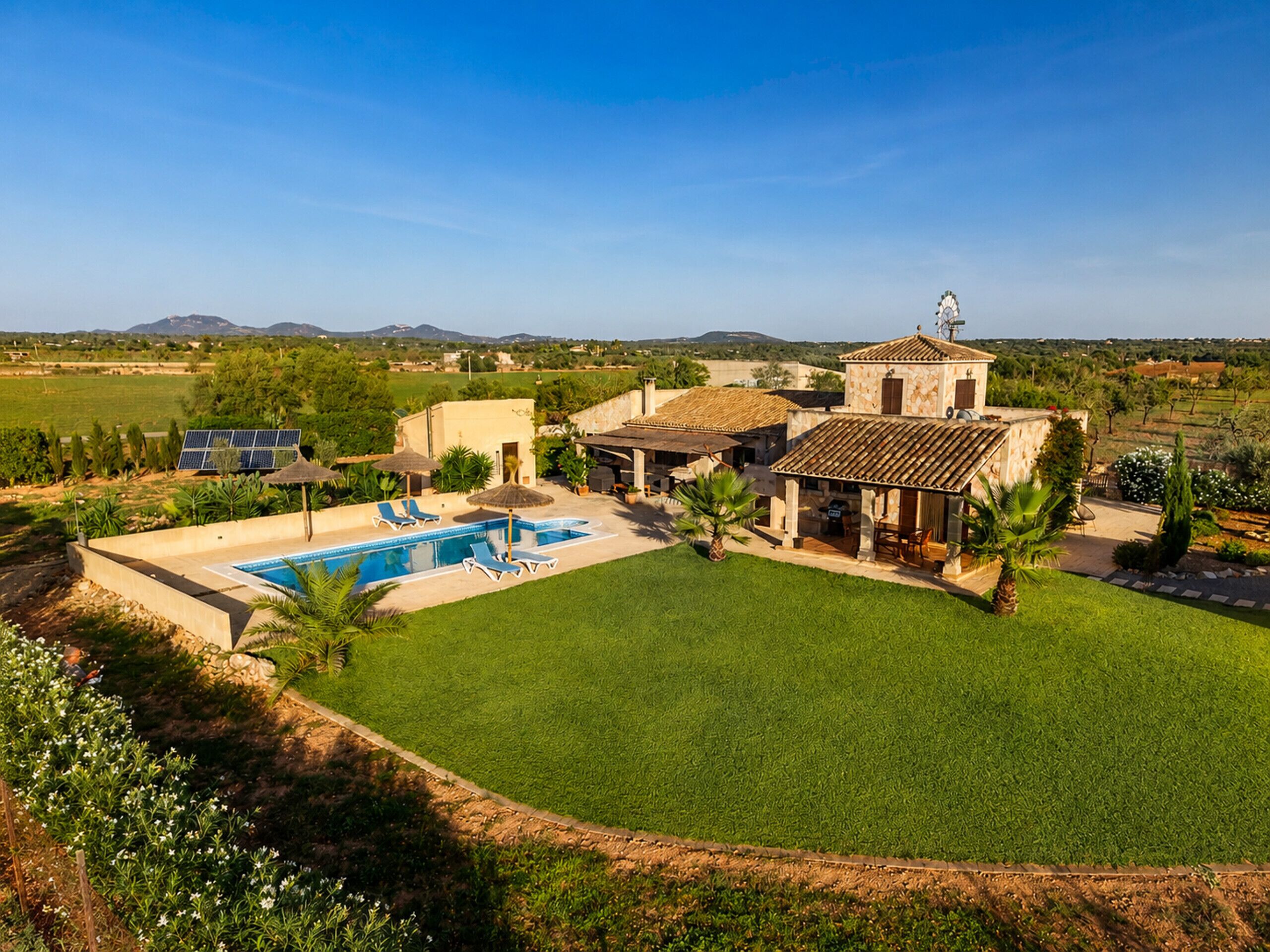 Ein Wohnhaus mit Schwimmbad, Sitzgelegenheit im Freien und Blick auf die umliegende Landschaft.