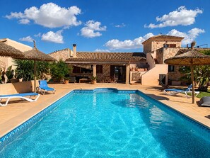 A swimming pool with lounge chairs, a stone building with a tiled roof, and a clear blue sky. - Canyop, 5StarsHome Villa, Mallorca (Campos)