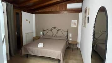 Un dormitorio con techo de madera, una cama con cabecera, un espejo redondo y un radiador.